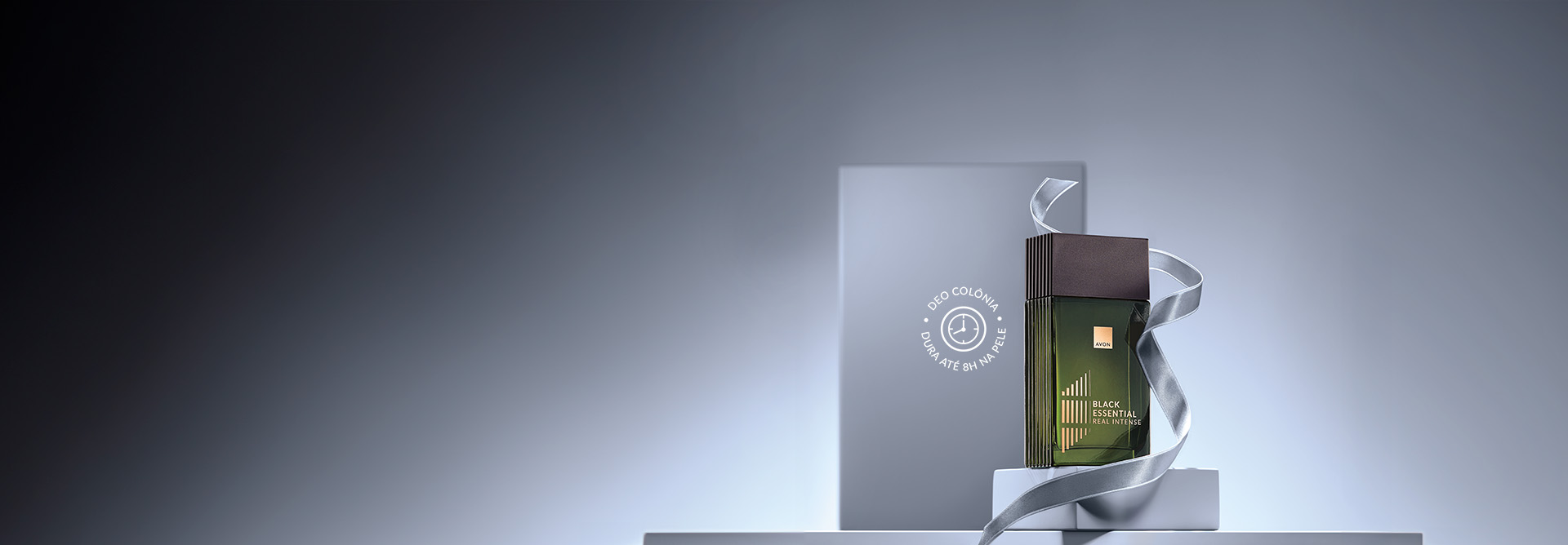 Fragrância Black Essential Real Intense sobre caixas e envolta por fita cinza em fundo cinza. 