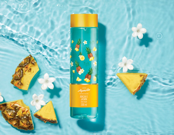 Frasco azul com amarelo de Aquavibe Abacaxi e Jasmim Body Splash sobre fundo aquoso azul com flores brancas e abacaxi cortado.