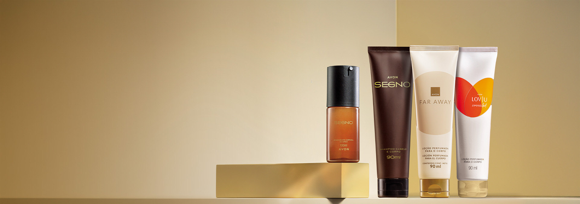 Banner com fundo dourado. Elementos incluem perfume Segno, shampoo Segno e loção Far Away sobre uma base dourada. Texto: "Corpo e Banho: presentes Avon para todos, da lembrancinha ao presentão."