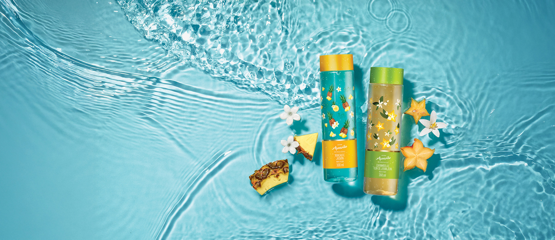 Frascos de Aquavibe Body Splash azul com amarelo de Abacaxi e Jasmim, e amarelo com verde de Carambola e Flor de Laranjeira sobre fundo aquoso azul com flores brancas, abacaxis e carambolas cortadas.