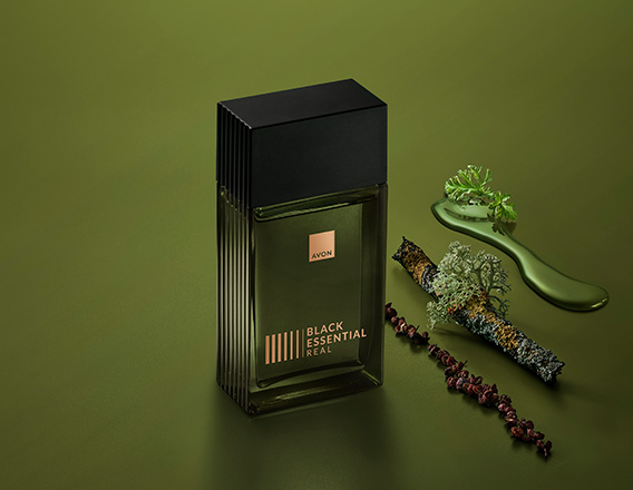 Fragrância Black Essential Real com ingredientes como pimentas e plantas, em fundo verde.