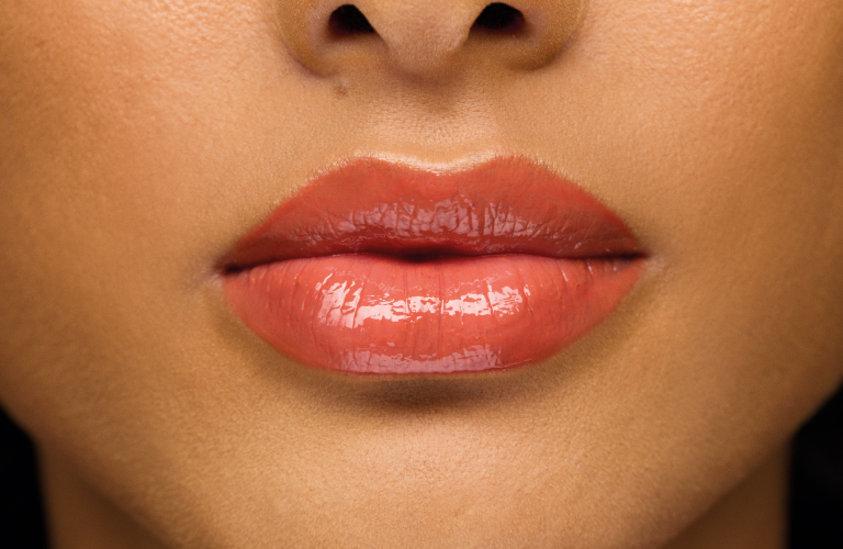Foto próxima dos lábios com lip balm caramelo.
