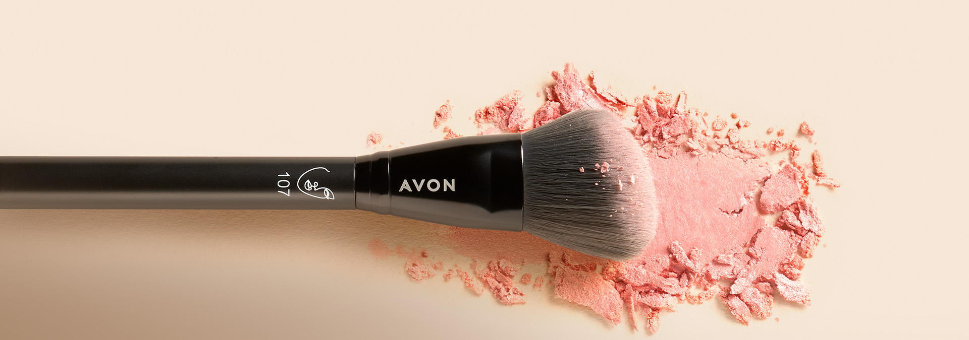 Banner com fundo em tons neutros, apresentando um pincel de maquiagem da Avon sobre um pó rosa esfarelado. O texto destaca "Pincel" e sugere a arte da maquiagem com pincéis perfeitos para cada detalhe.