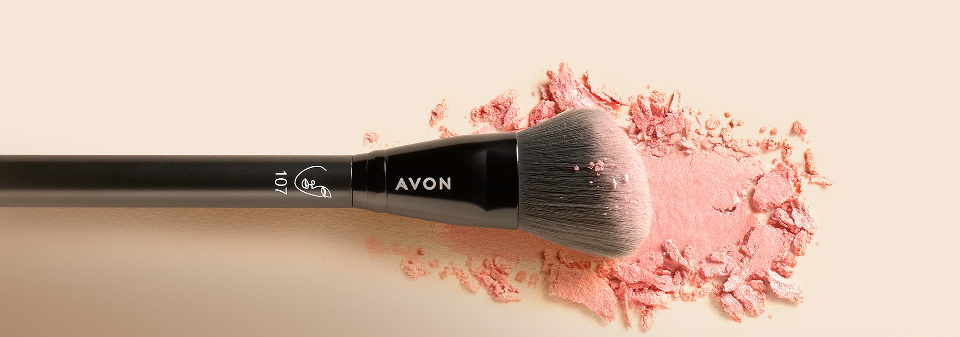 Banner com fundo em tons neutros, apresentando um pincel de maquiagem da Avon sobre um pó rosa esfarelado. O texto destaca "Pincel" e sugere a arte da maquiagem com pincéis perfeitos para cada detalhe.
