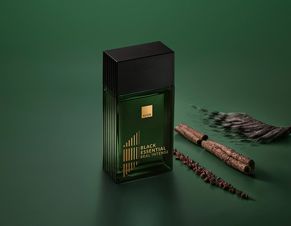 Fragrância Black Essential Real com ingredientes como pimentas e plantas, em fundo verde.