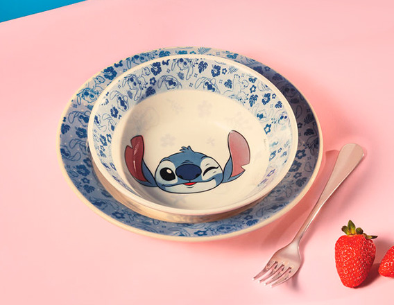 Prato Stitch sobre mesa rosa. Ao lado do item, há um garfo e morangos.