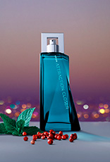 Fragrância Avon Attraction Closer para Ele em bancada cinza com ingredientes, como menta e pimenta, em fundo de entardecer de uma cidade iluminada.