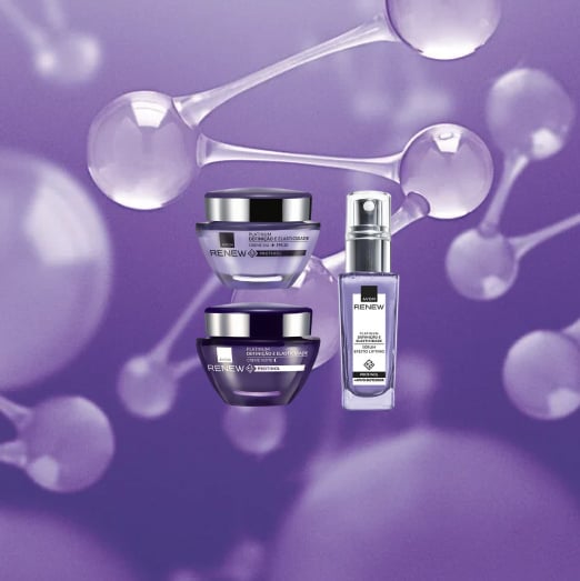 Embalagens roxas de Renew Platinum: potes empilhados de Creme Dia e Creme Noite e frasco com válvula de Sérum Lift & Firmeza, em fundo roxo com moléculas translúcidas.