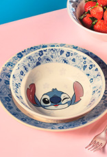 Prato Stitch sobre mesa rosa. Ao lado do item, há um garfo e morangos.