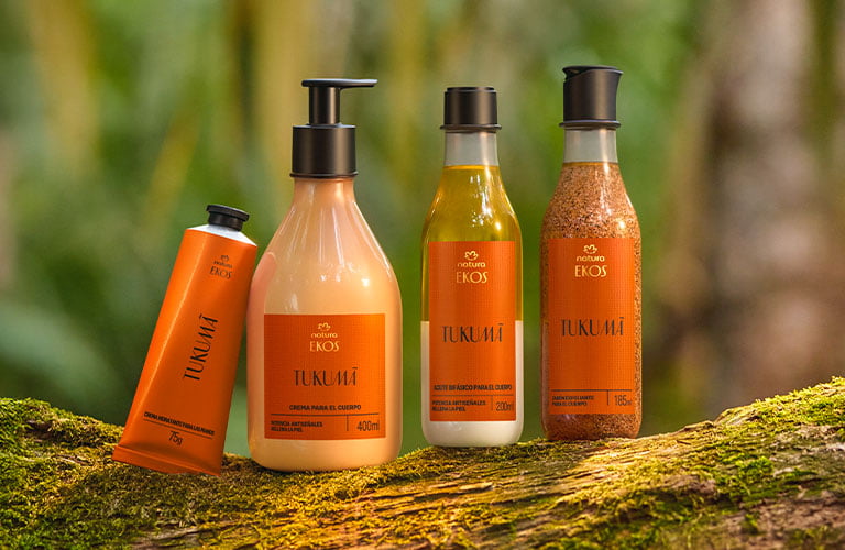 Kit de productos Ekos Tukuma colocados sobre un tronco en la selva amazónica de Brasil.