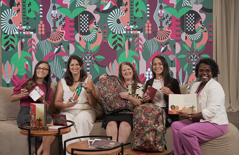 Cinco mujeres felices porque ya saben cómo ser revendedoras Natura, sentadas en un sillón.