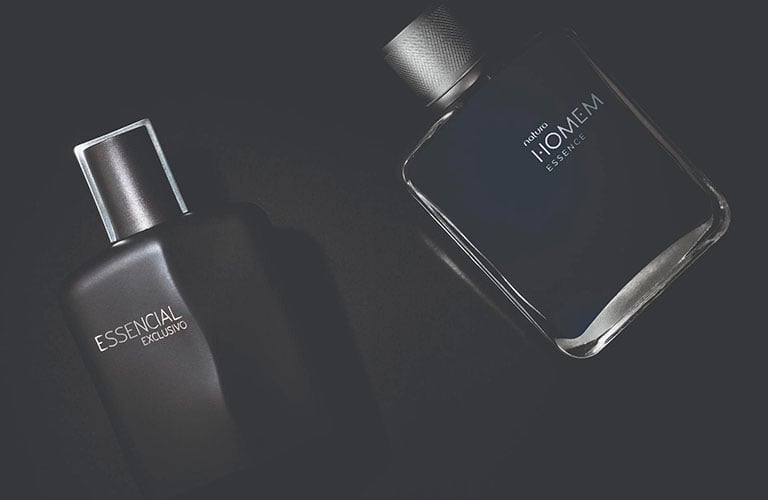 fotografia de dos perfumes Natura: Essencial y Homem en tonos grises.