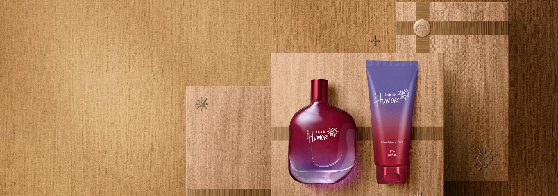 Sobre un fondo marrón con cajas de regalos, un Beijo de Humor masculino eau de toilette y un Balm post barba 