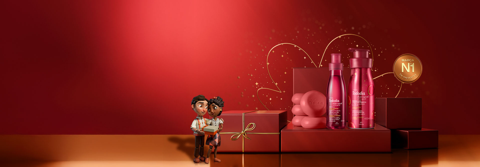 Fundo vermelho com detalhes e linhas douradas e selo onde é possível ler "Marca No 1 em Presentes". Do lado esquerdo, casal de bonecos de mdeira segurando presentes. Ao centro, sobre caixas de presente vermelhas, aparece uma sequência de Kits de Presentes da Natura.