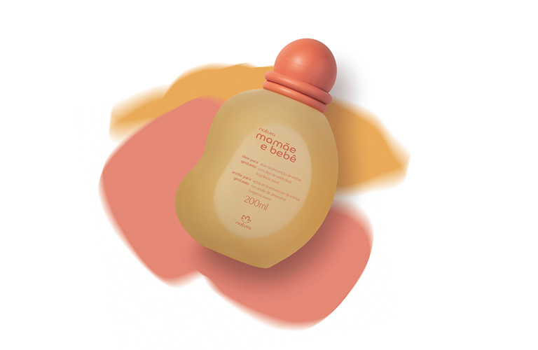 Óleo para Gestante da linha Mamãe e Bebê para uma automassagem na barriga sobre um fundo rosa, laranja e branco