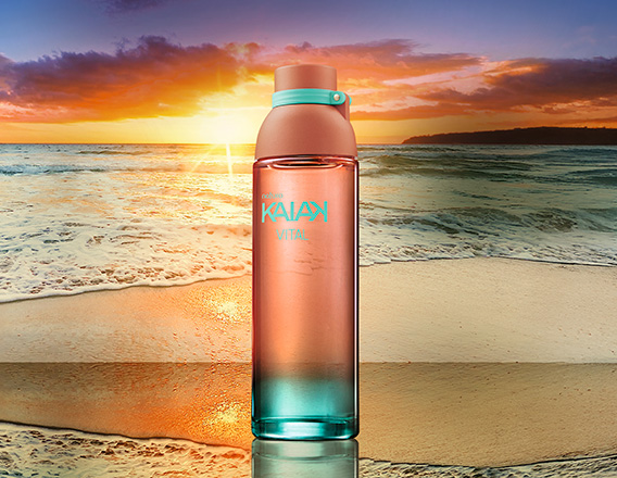 Frasco da fragrância Kaiak Vital feminino em coral com degradê turquesa. Fundo de praia com mar e pôr do sol alaranjado.