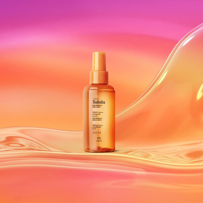 Frasco spray laranja de Água Prebiótica Tododia Manga Rosa e Água de Coco sobre grafismo e fundo em laranja com rosa.