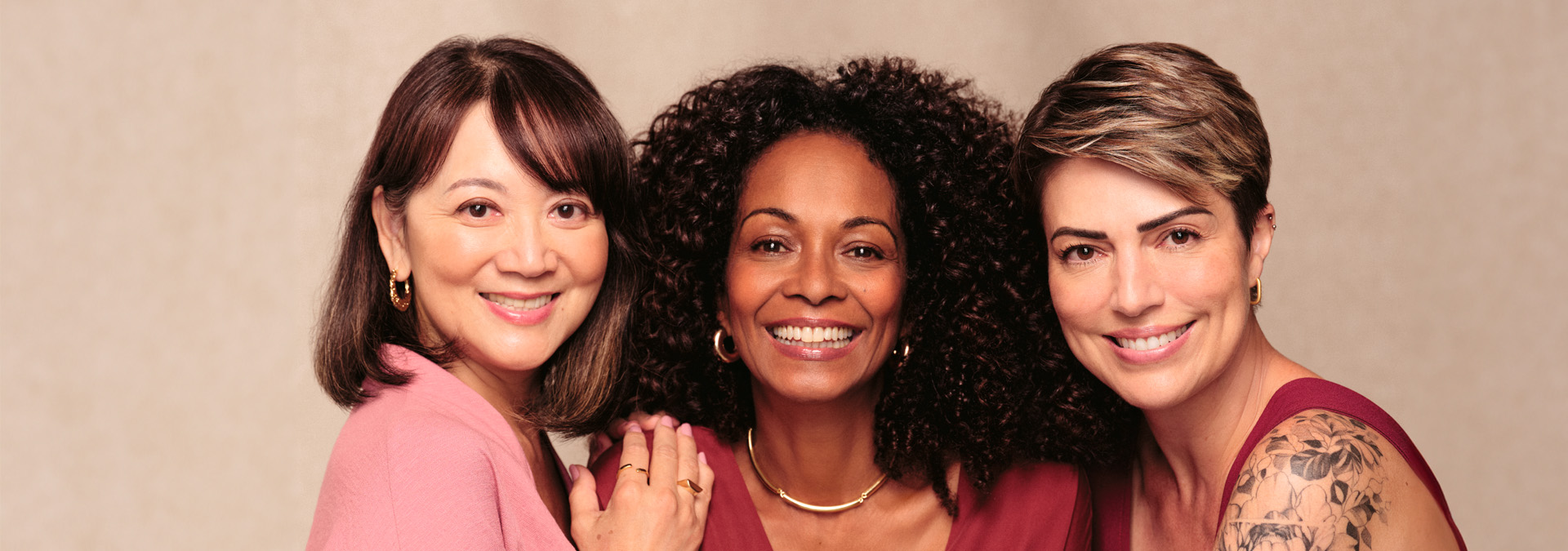 Três mulheres de diferentes idades posam lado a lado, transmitindo a mensagem de beleza diversa e atemporal.