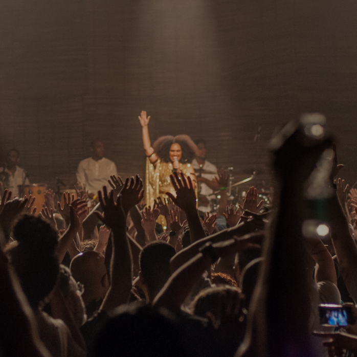 Imagem de um público aproveitando um show no Coala Festival em São Paulo, com a frase "experiências e festivais" em destaque sobreposta.
