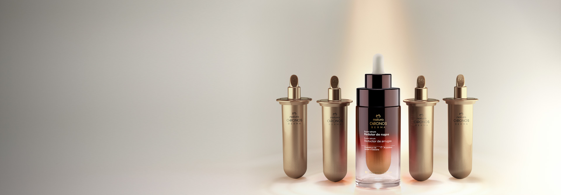 Na imagem,Super Sérum Redutor de Rugas Chronos Derma aparece no canto direito da tela com dois refis de cada lado, em fundo claro com tons de bege e dourado.