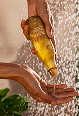 Produto Natura Ekos sendo aplicado em uma mão durante o banho.