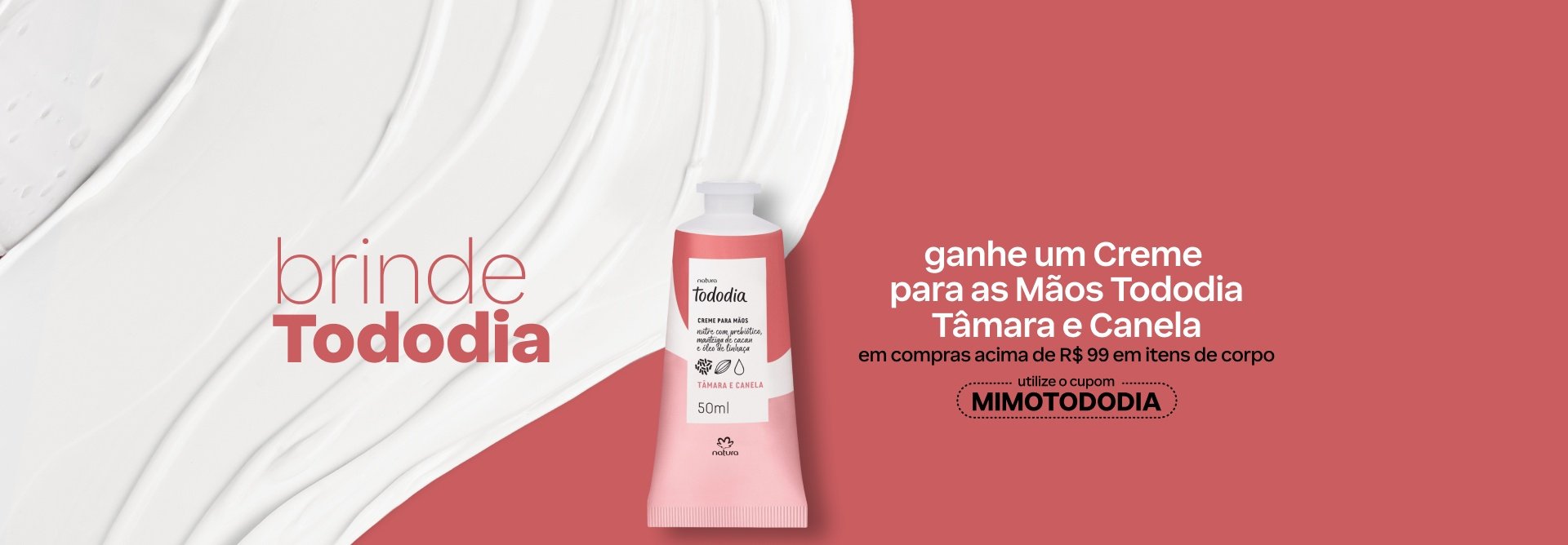 Creme para as Mãos Tododia Tâmara e Canela em bisnaga branca com detalhes rosa. Está sobre fundo rosa com creme branco espalhado. Texto: brinde Tododia. Ganhe um Creme para as Mãos Tododia Tâmara e Canela em compras acima de R$ 99 em itens de corpo. Utilize o cupom MIMOTODODIA.