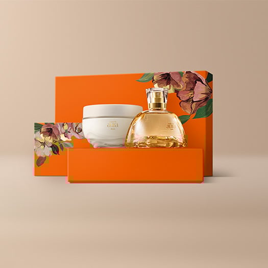 Presente Natura Aura Alba Completo com Eau de Parfum e Creme Aveludado Corporal sobre caixas laranja com ilustrações florais, em fundo bege.