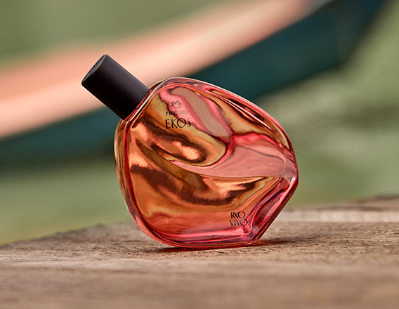 Com tonalidades quentes em vermelho e dourado, Desodorante Colônia Natura Ekos Ryo Chuva repousa sobre madeira. A cena inspira movimento, paixão e a conexão vibrante com a natureza.