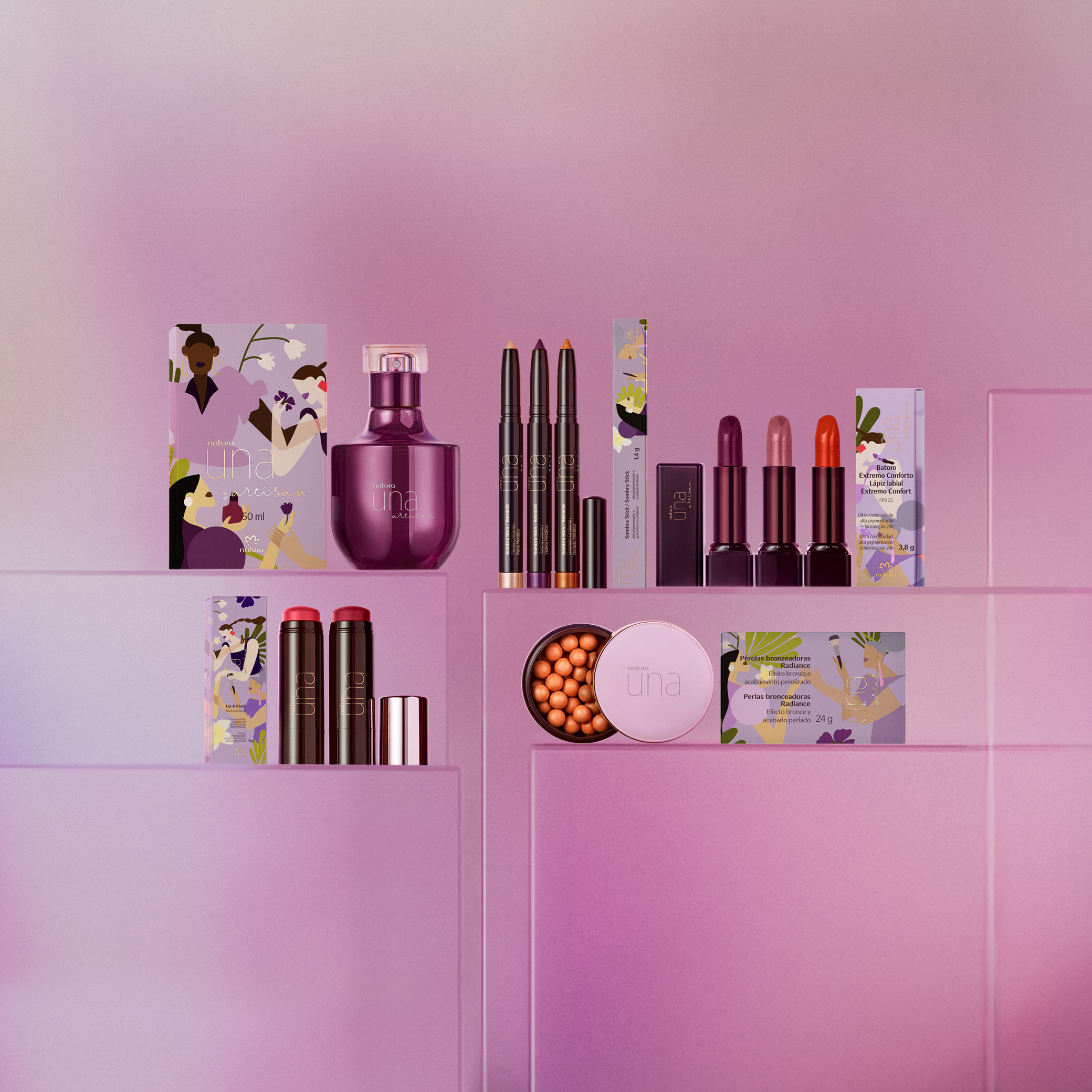 Produtos variados da coleção Una Artisan organizados em duas fileiras sobre caixas lilás, incluindo batons, perfume, sombra, stick multifuncional e blush. Todos possuem caixas ilustradas combinando. 