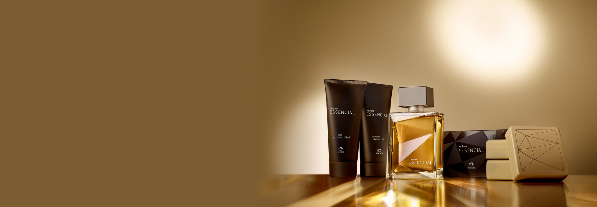 Presente Essencial Masculino com Balm Pós-barba, Creme de Barbear, Deo Parfum e três Sabonetes em Barra aparece iluminado sobre superfície dourada em fundo dourado.