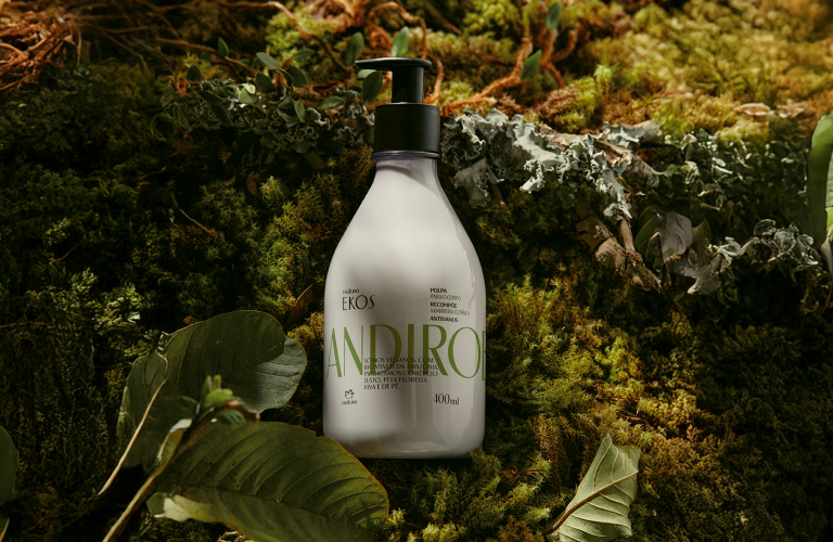 Creme hidratante corporal da linha Ekos Andiroba sobre vegetação cheia de musgos e folhas