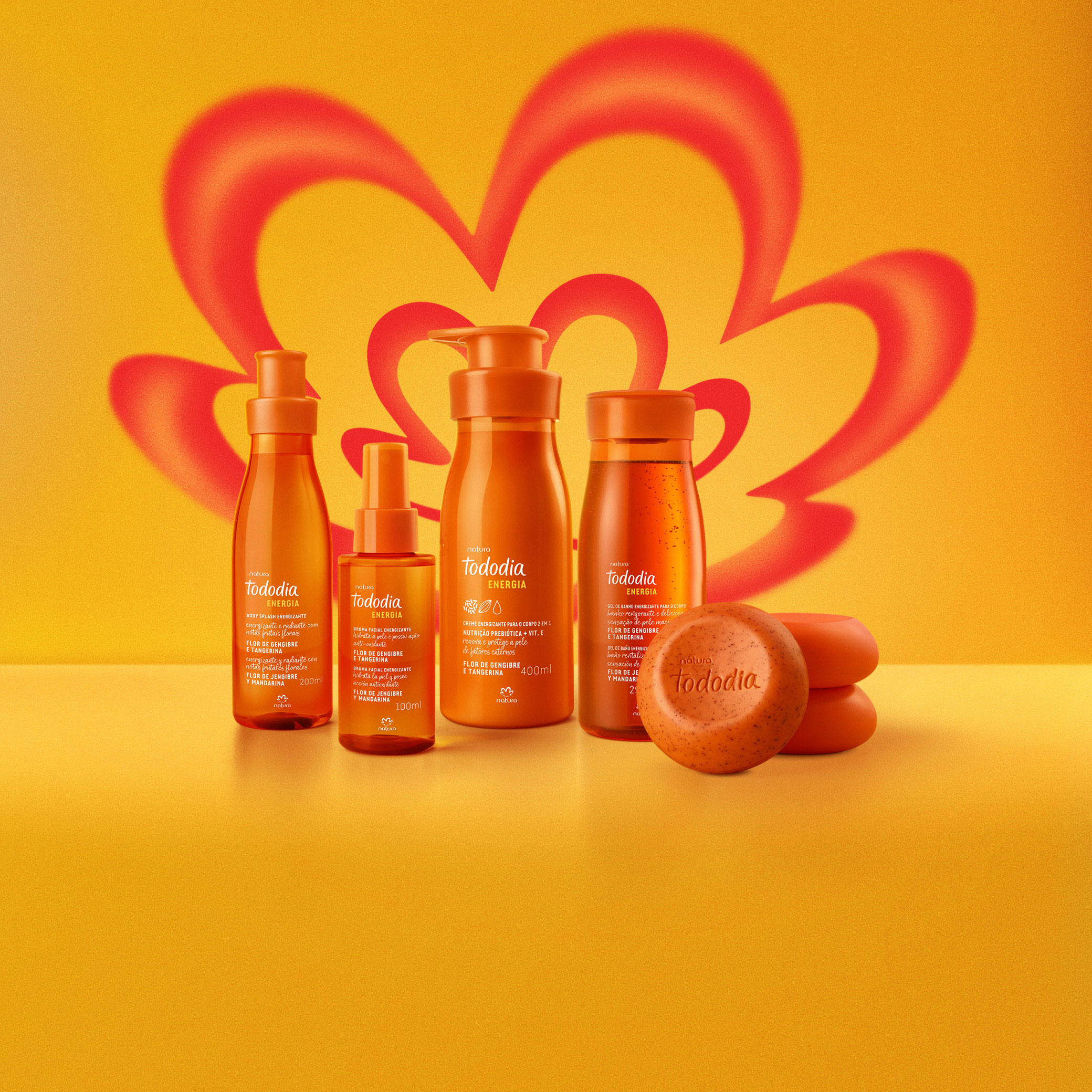 Produtos da linha Tododia Energia em fundo laranja vibrante, incluindo Body Splash, Bruma Facial, Creme Corporal, Gel de Banho e Sabonetes redondos. Todas as embalagens têm tom laranja vibrante. 