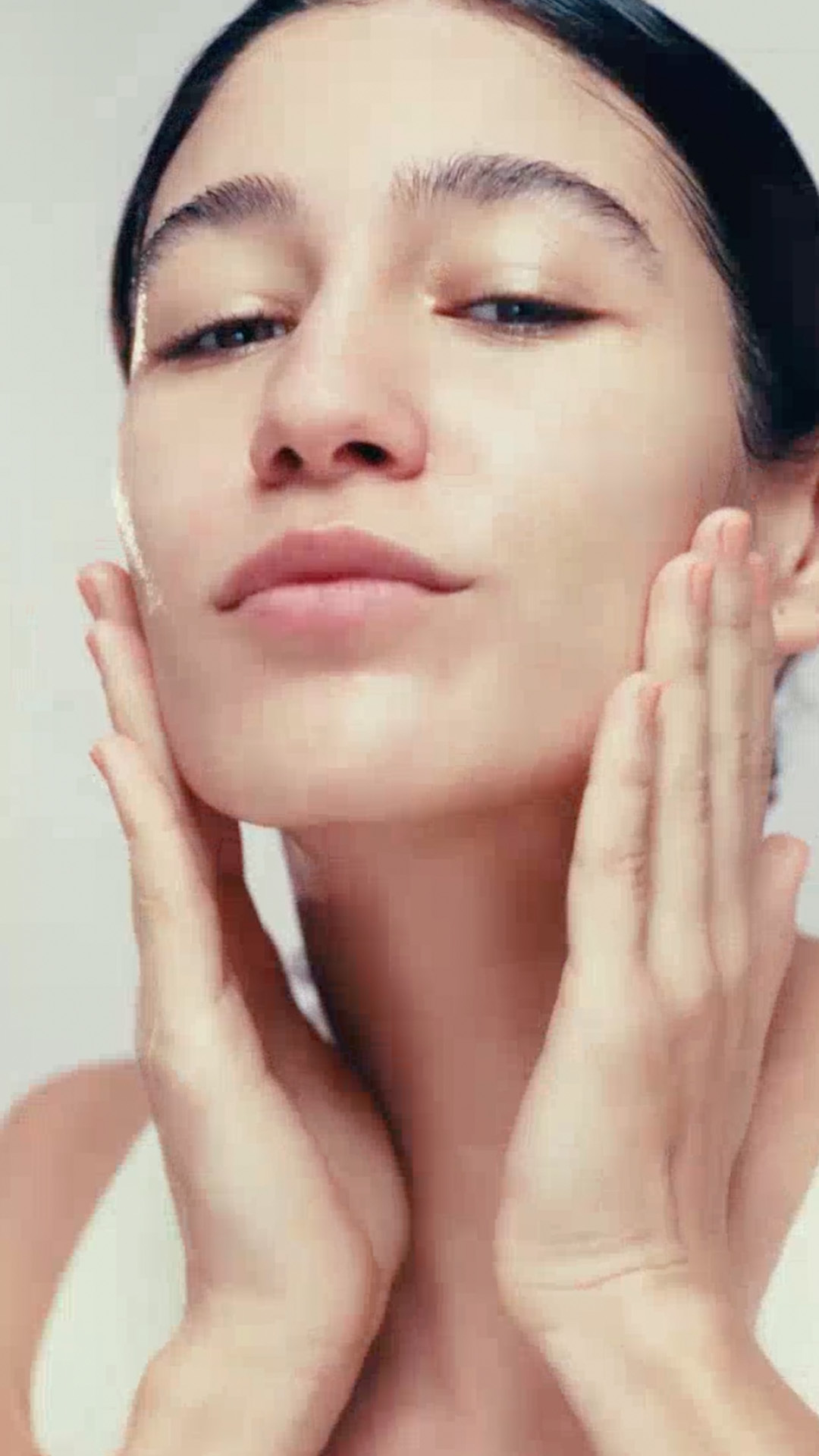Modelo mostra a embalagem da Máscara Refrescante Faces. Logo em seguida, ela aplica a máscara no rosto e massageia sua pele em movimentos suaves.