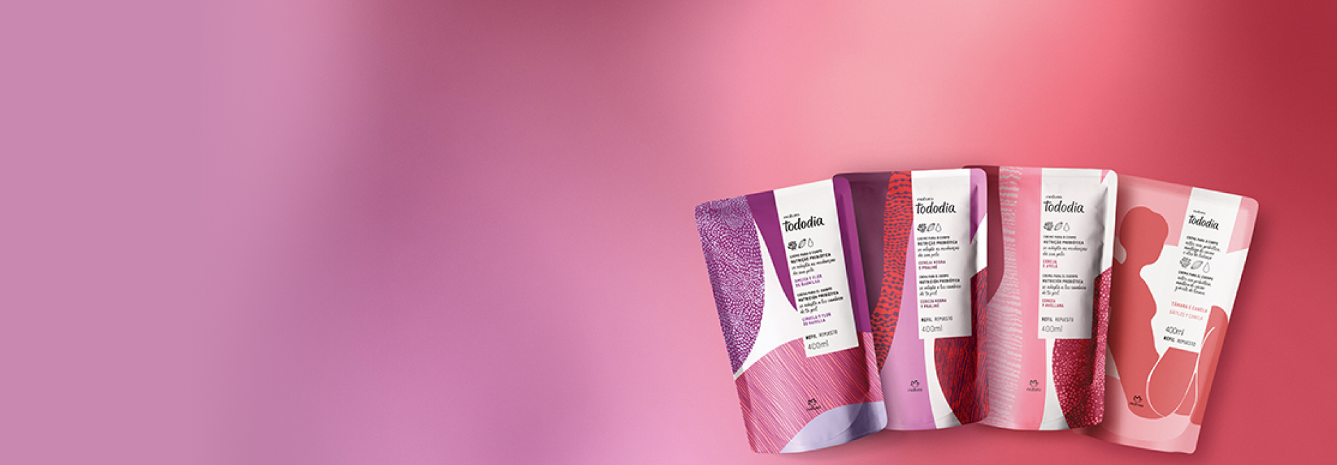 Refis dos Cremes Nutritivos para o Corpo Natura Tododia Ameixa e Flor de Baunilha, Cereja Negra e Praliné, Cereja e Avelã e Tâmara e Canela aparecem em destaque sobre fundo roxo-avermelhado.