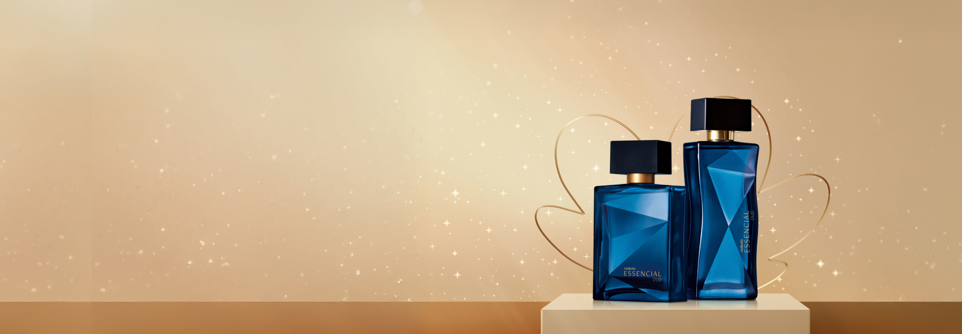 As fragrâncias Natura Essencial Oud Masculino e Feminino, com frascos de vidro azuis-escuros e tampas pretas, destacam-se sobre fundo dourado com pequenas estrelas e a flor símbolo da Natura.