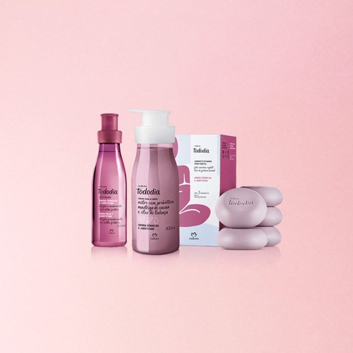 Em fundo rosa-claro, produtos da linha Natura Tododia Amora Vermelha e Jabuticaba: Body Splash, Loção Hidratante e Sabonetes com caixa.