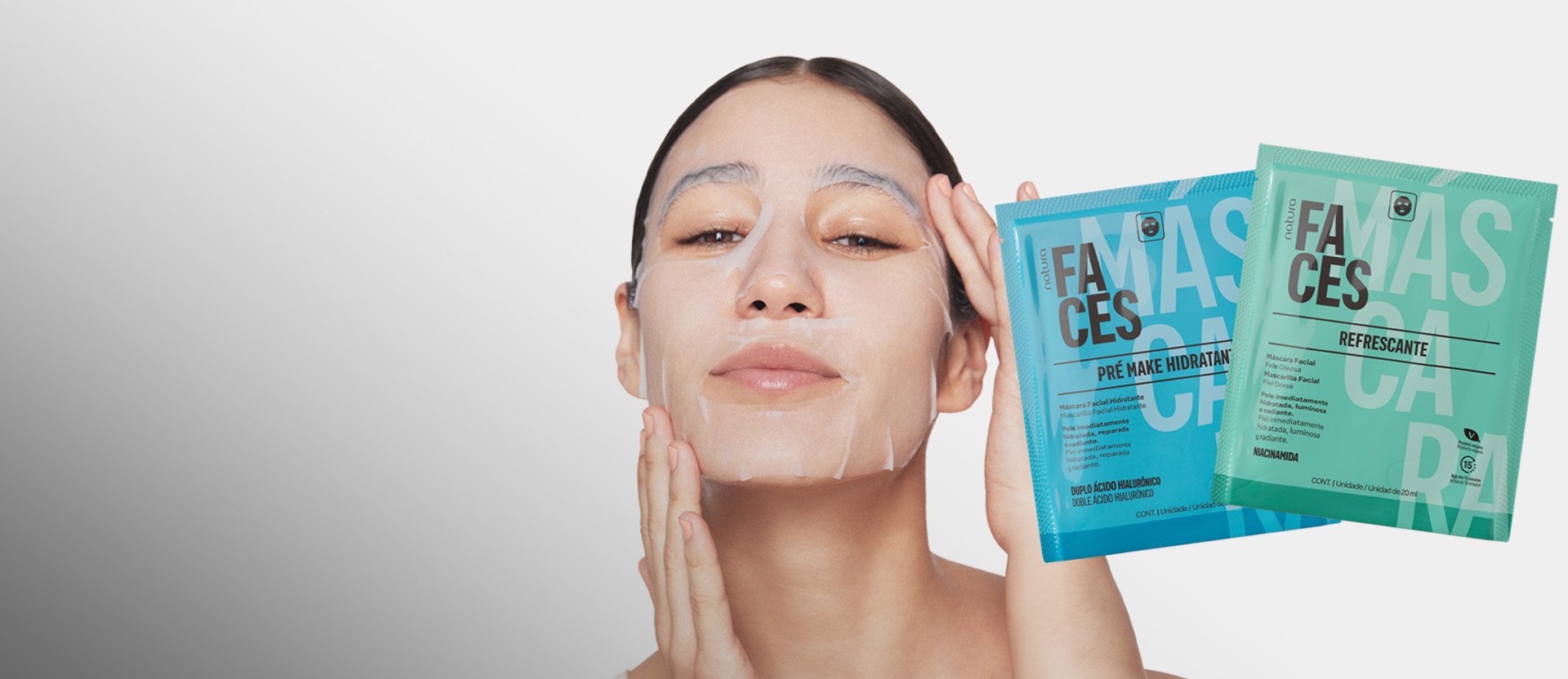 Em fundo branco, mulher posa usando uma máscara facial, com dois produtos da linha Natura Faces Máscara à direita.