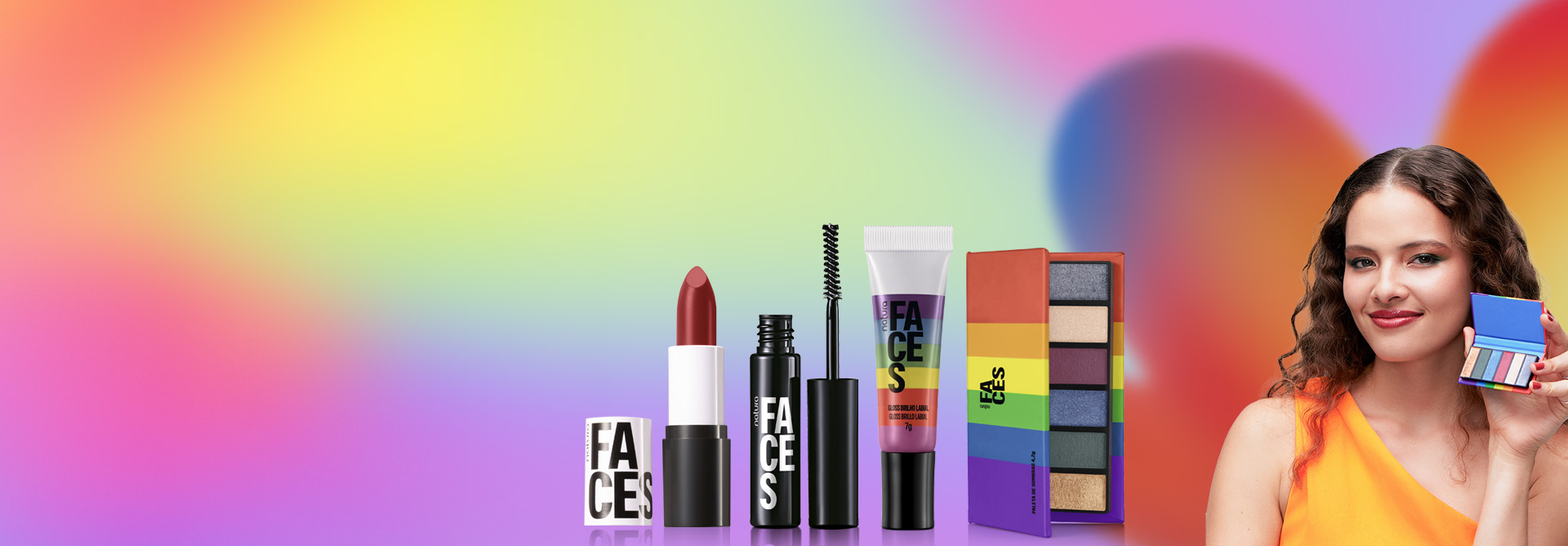 Batom Multimix, Gel de Sobrancelhas Incolor, Gloss Multicolor e Paleta de Sombras da Coleção do Amor de Faces em destaque sobre fundo multicolorido. Ao lado, modelo segura Paleta nas mãos e sorri.