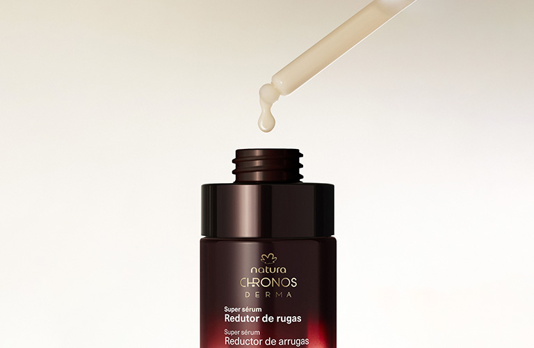 Super Sérum Redutor de Rugas Chronos Derma com seu conta gotas saindo do pote e pingando uma gota