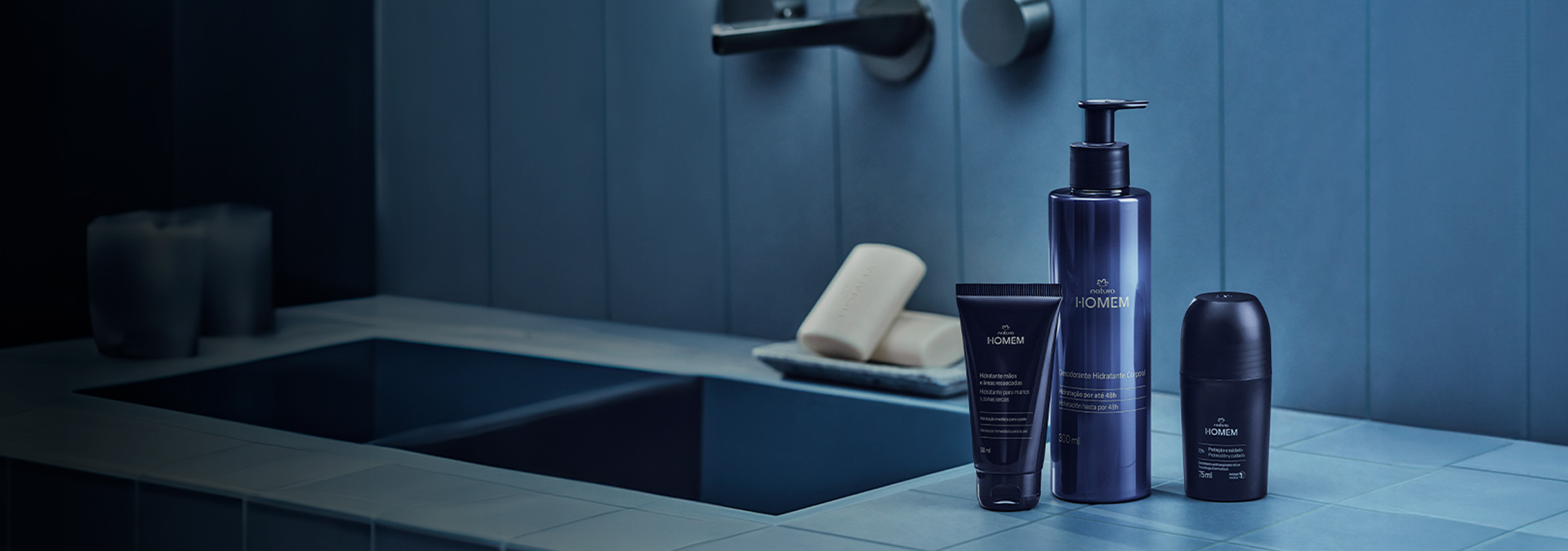 Fundo com tons de Azul claro e escuro, ao lado direito produtos da linha corpo e banho de Natura Homem.