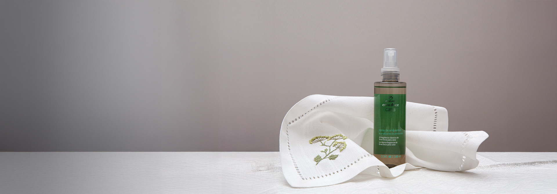 Spray para Ambientes e Difusor de Ambiente em bancada branca com flores de erva doce em fundo branco.