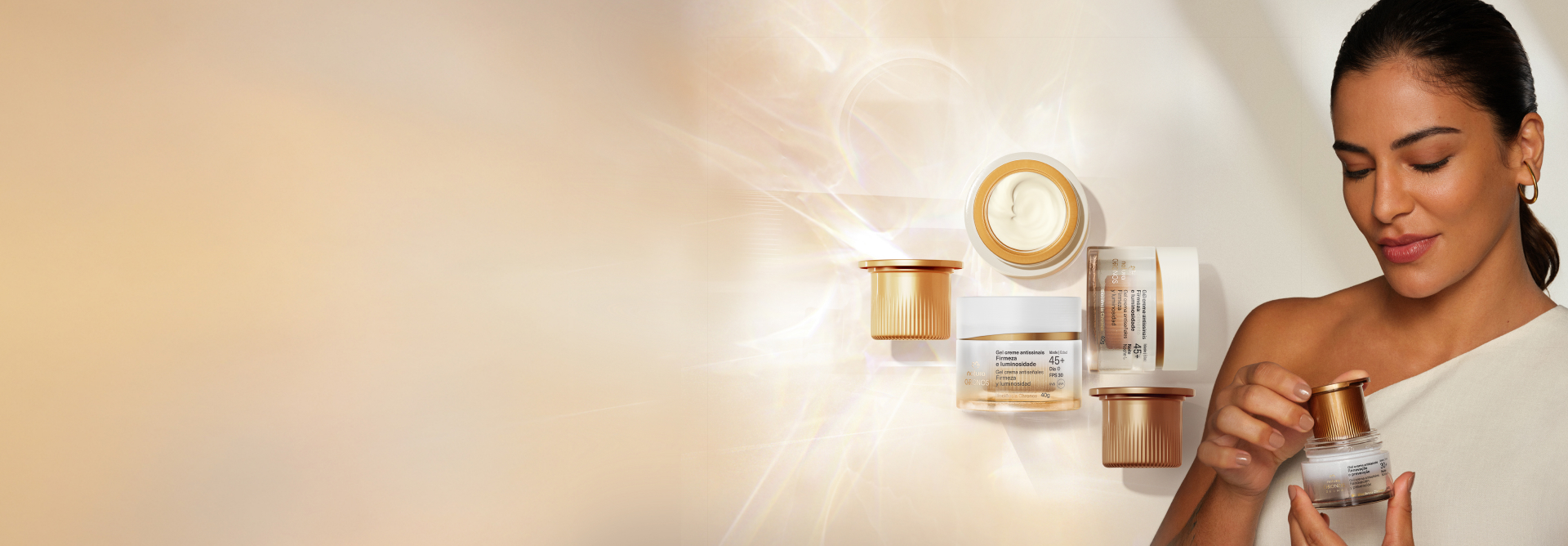 Refis e produtos Natura Chronos sobre base iluminada na cor creme. À direita dos produtos, mulher de cabelos presos repõe refil em um produto Natura Chronos.