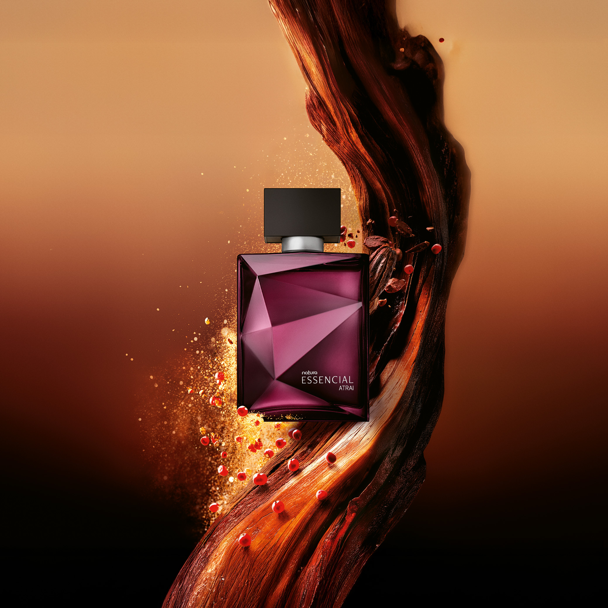 Frasco Deo Parfum Essencial Atrai Masculino em tons de vinho e prata em destaque sobre madeiras e pimenta rosa, elementos que remetem aos ingredientes. Fundo alaranjado. 