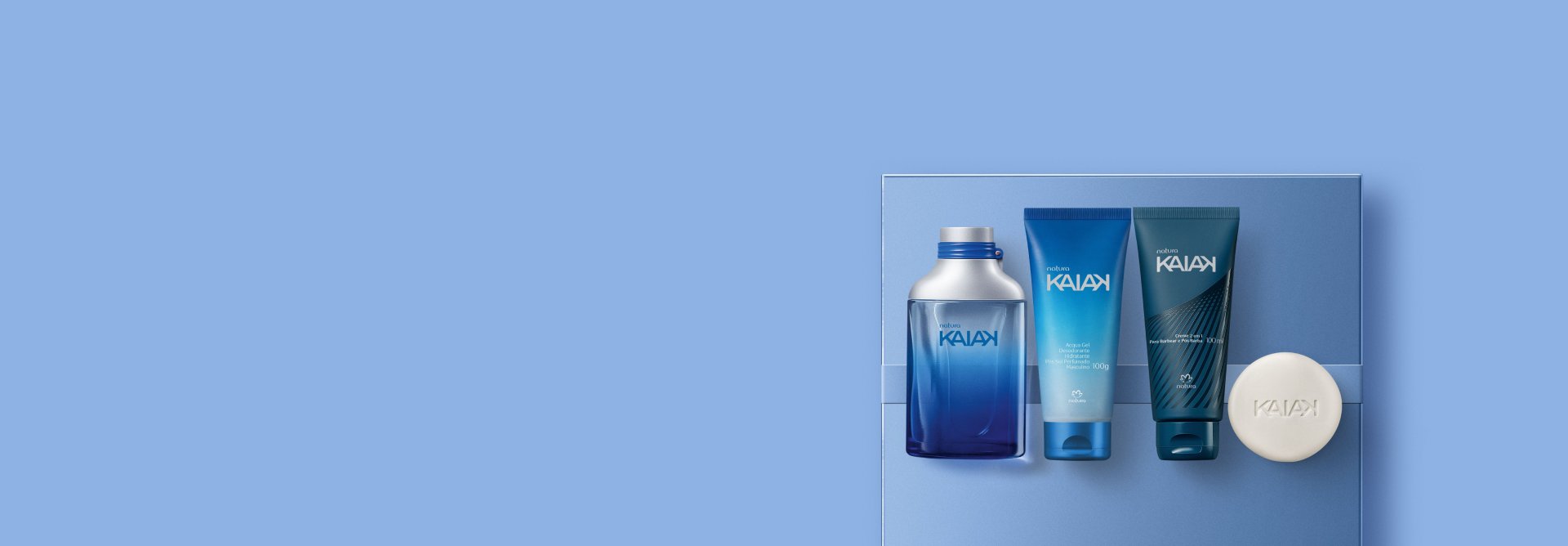 Presente Natura Kaiak Masculino, contendo 1 Desodorante Colônia, Acqua Gel Desodorante Hidratante Corporal, 1 Creme 2 em 1 para Barbear e Pós-barba e 1 Sabonete em Barra. Itens sobre fundo azul-claro.