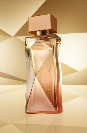 Frasco de Essencial Feminino, em tons de rosê e tampa dourada, aparece em destaque no centro da tela sobre fundo multifacetado dourado, fazendo alusão ao design do frasco de Essencial.