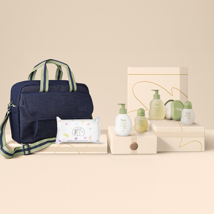Produtos Natura Mamãe e Bebê com bolsa sobre caixas presenteáveis e fundo na cor creme.
