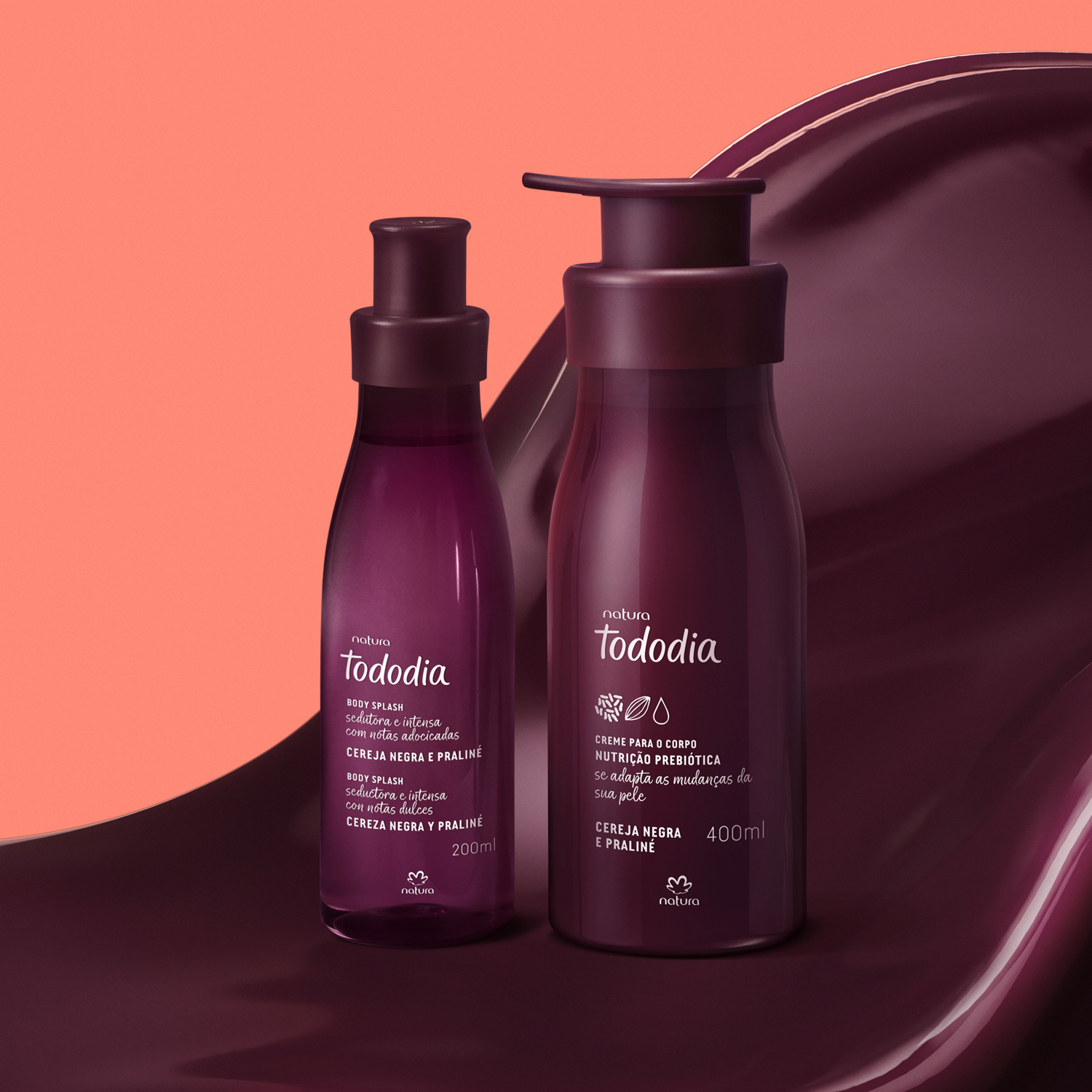 2 produtos de Tododia Cereja Negra e Praliné, sendo 1 frasco de body splash e 1 frasco pump de creme, ambos com embalagens roxas, repousam sobre uma textura cremosa na cor cereja-negra.