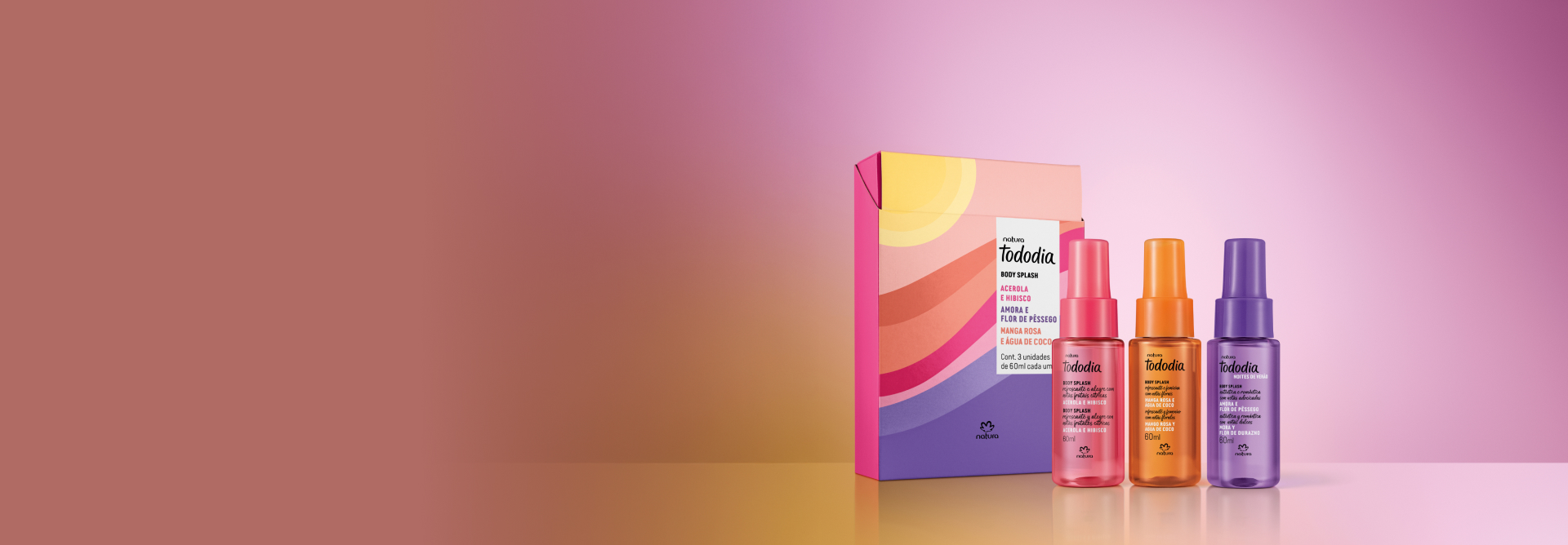 Kit Tododia Body Splash Miniaturas Verão, com as fragrâncias Manga Rosa e Água de Coco, Acerola e Hibisco e Amora e Flor de Pêssego, destaca-se ao lado de caixa decorada. Fundo rosa e amarelo.