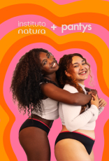 Mulher negra e mulher branca sorriem, abraçadas, vestindo tops brancos e calcinhas pretas com detalhe rosa. Logo Instituto Natura + pantys, à direita. Fundo com formas em tons de rosa e laranja.