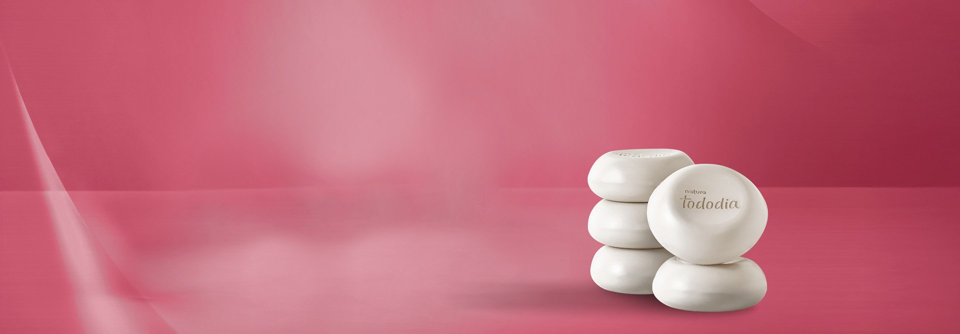 4 Sabonetes em Barra Tododia Cereja e Avelã sobre fundo vermelho. As barras de sabonetes são redondas e brancas.